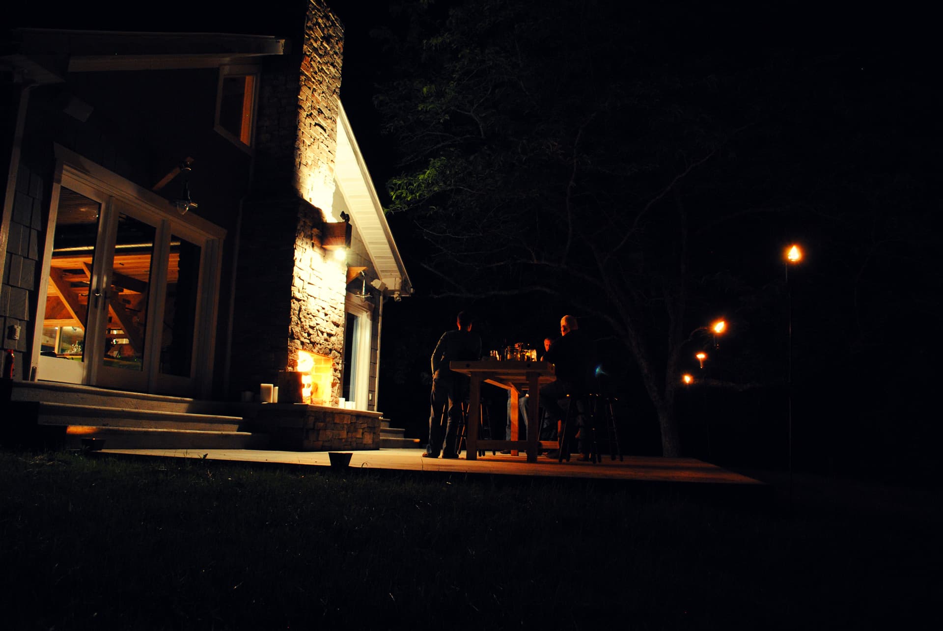 Farmhouse at night with warm lights glowing