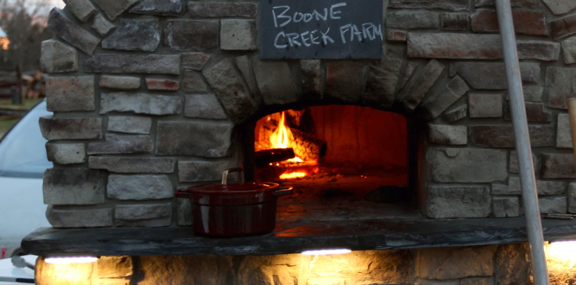 Wood-fired pizza oven with Boone Creek Farm sign